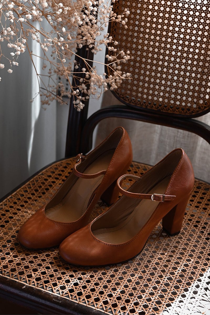 Top-down flat lay of Ainsley women's brown adjustable sandals on a neutral surface