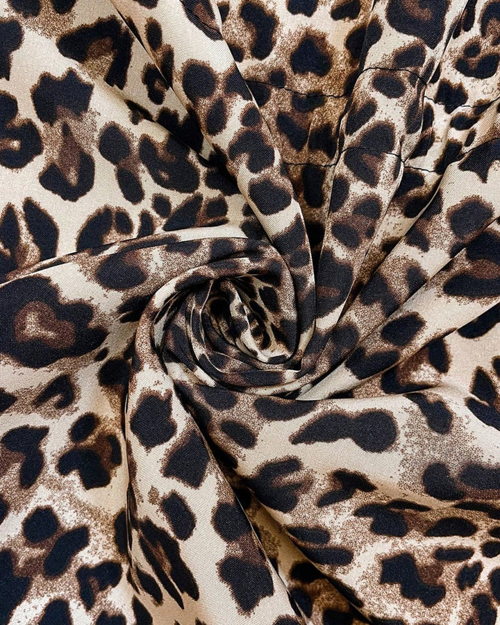 Model wearing the Aleah coat in white leopard side out in an urban setting