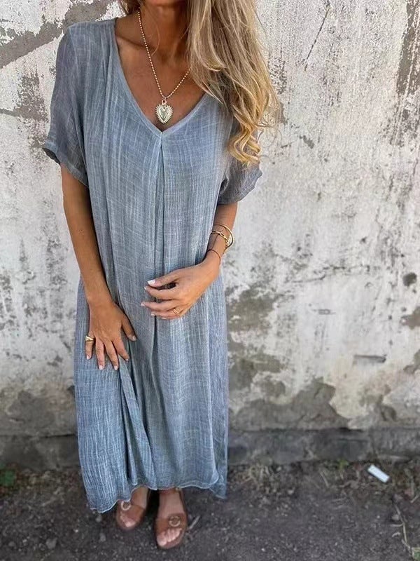 Model in a loose V-neck dress in blue, showcasing the flowy fabric and easy everyday style