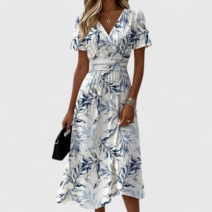 Woman wearing a floral white V-neck wrap midi dress with flutter short sleeves and an elasticated waist, styled with sandals