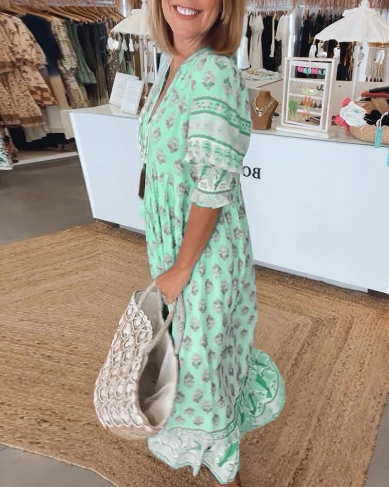 Model styling boho midi tassel dress with sandals and a woven bag for a vacation look