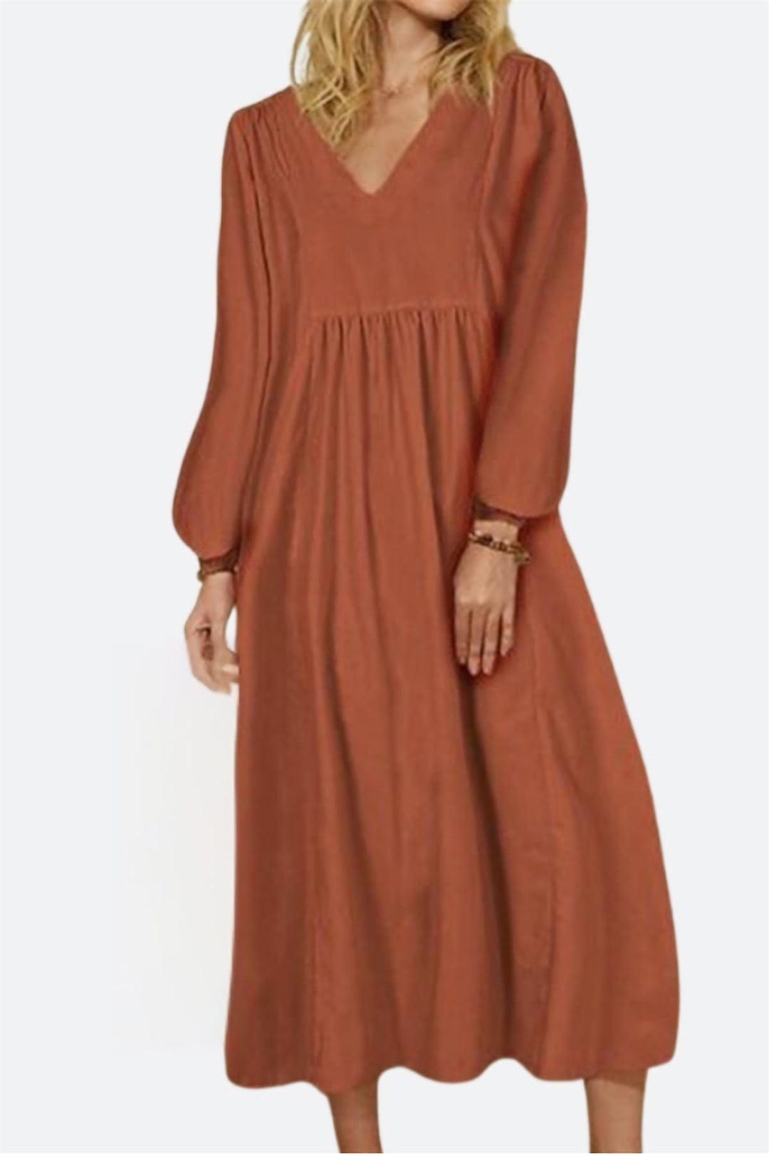 Woman wearing a red brick v-neck smocked waist midi dress with balloon sleeves, front view