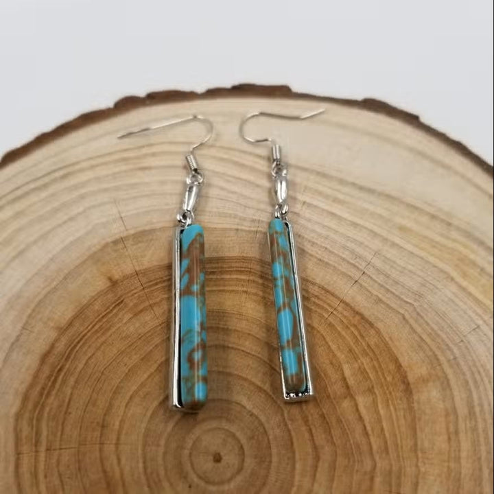 Vintage turquoise drop earrings shown from a side angle highlighting their length and design