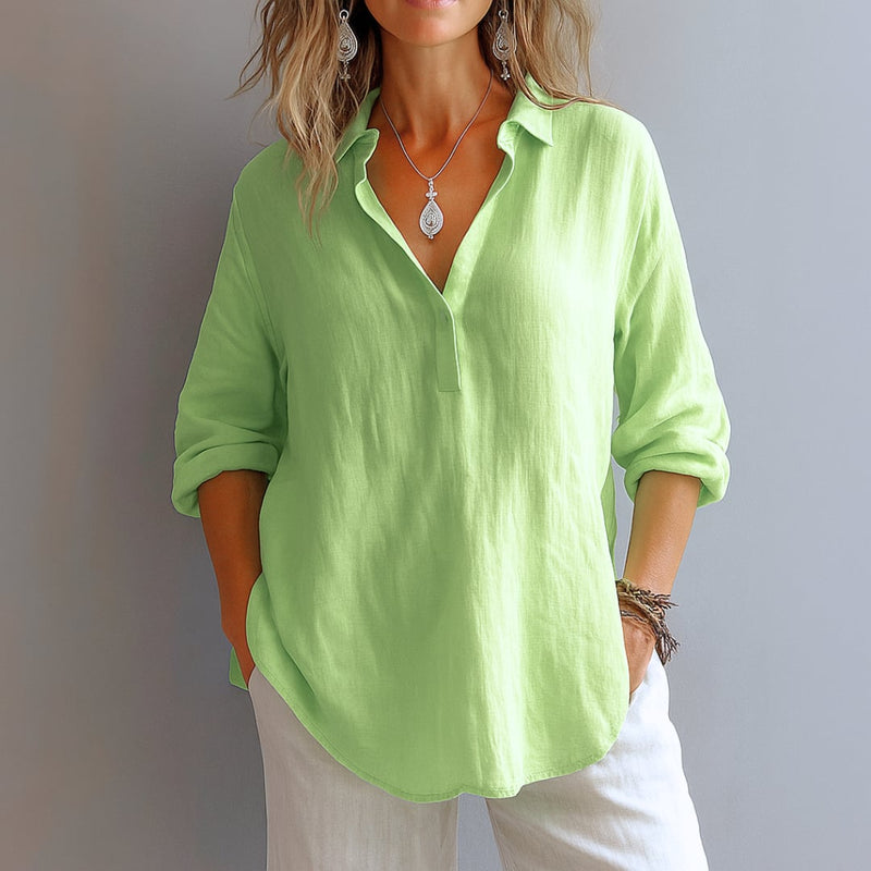 Front view of a relaxed-fit V-neck blouse tucked into high-waisted jeans for a polished everyday look