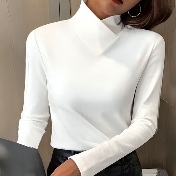 Woman wearing a white fitted turtleneck top with a tailored silhouette, front view
