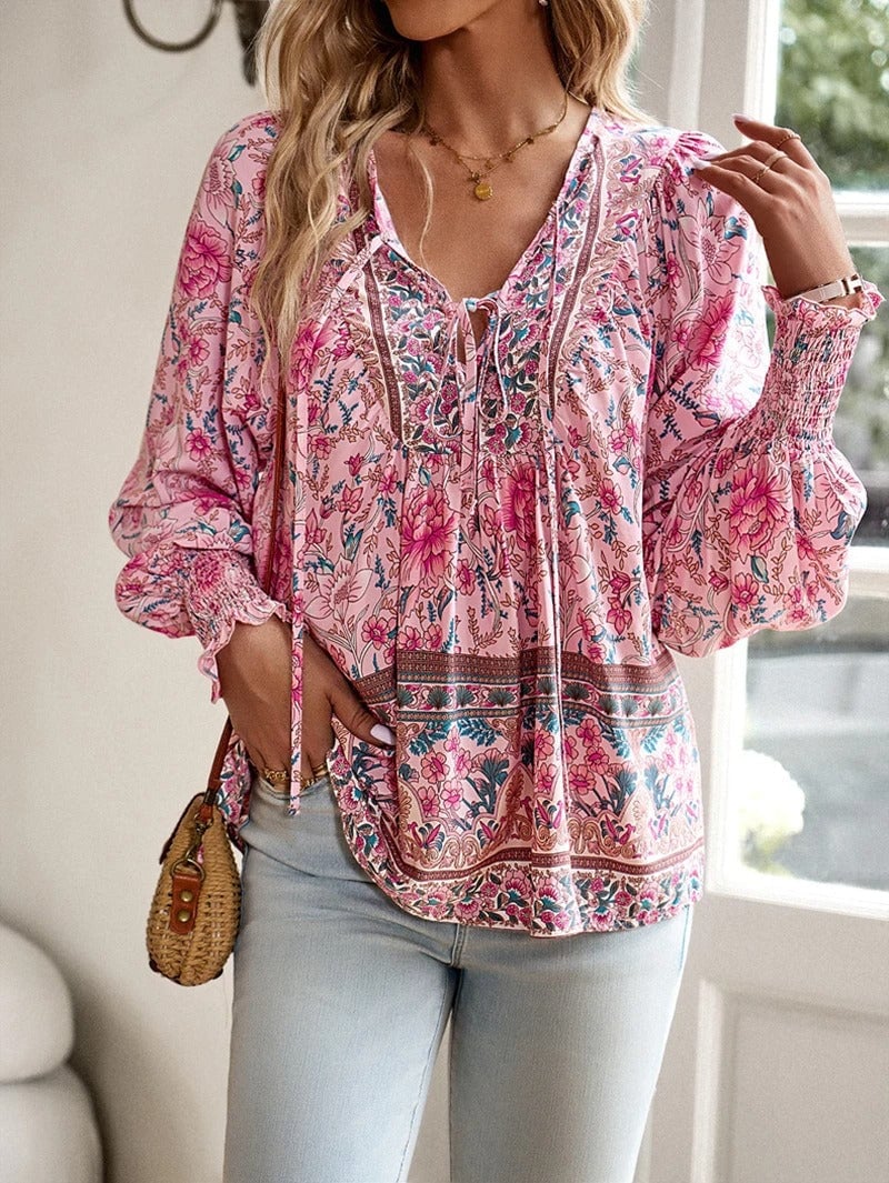 Model wearing a pink summer floral top with a relaxed drawstring silhouette against a bright background