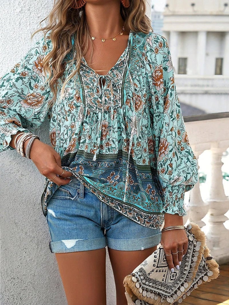 Overhead flat lay of the summer floral top in all four color options pink blue green and orange