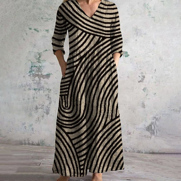 Woman wearing a brown and black vintage striped V-neck dress with a flowing silhouette, styled for a casual daytime look