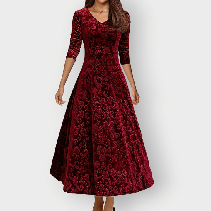 Woman wearing a rich red vintage velvet midi dress with a flattering curved silhouette, front view