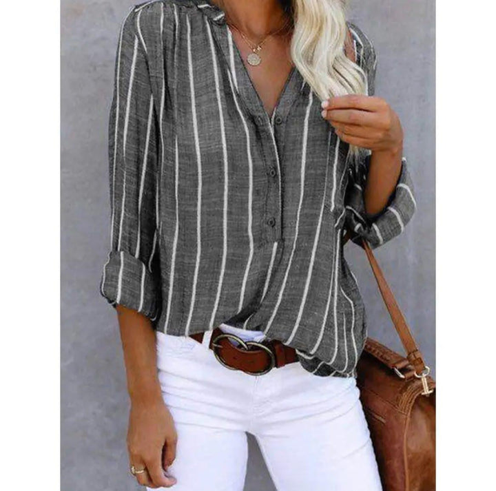 Gray striped blouse laid flat showing vertical stripe pattern and button-down front