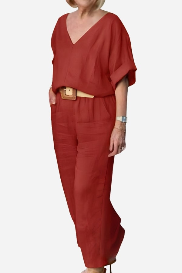 Woman wearing the Carmen red orange V-neck batwing top and straight-leg pants two-piece set, front view