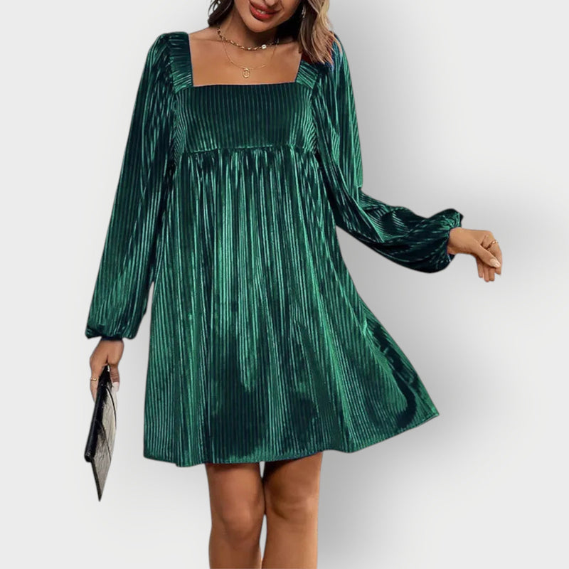 Model wearing a dark green velvet backless dress with a sleek, form-fitting silhouette