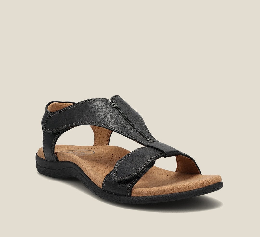 Woman wearing Carolyn orthopedic sandals in blue while walking on a sunny city street