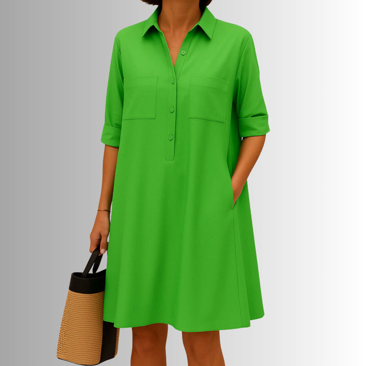 Woman wearing a lightweight A-line button dress with decorative front buttons and a modern collar in green