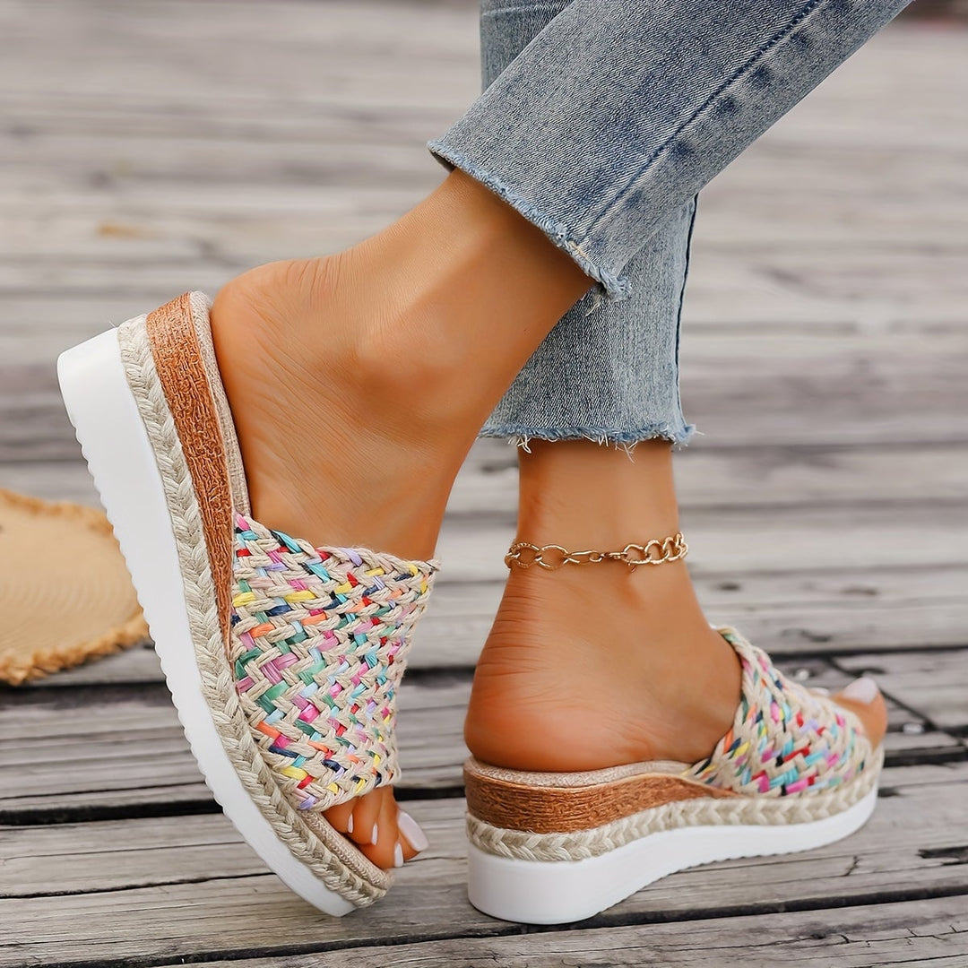 Pair of Celeste woven wedge sandals in beige arranged flat lay on a neutral surface