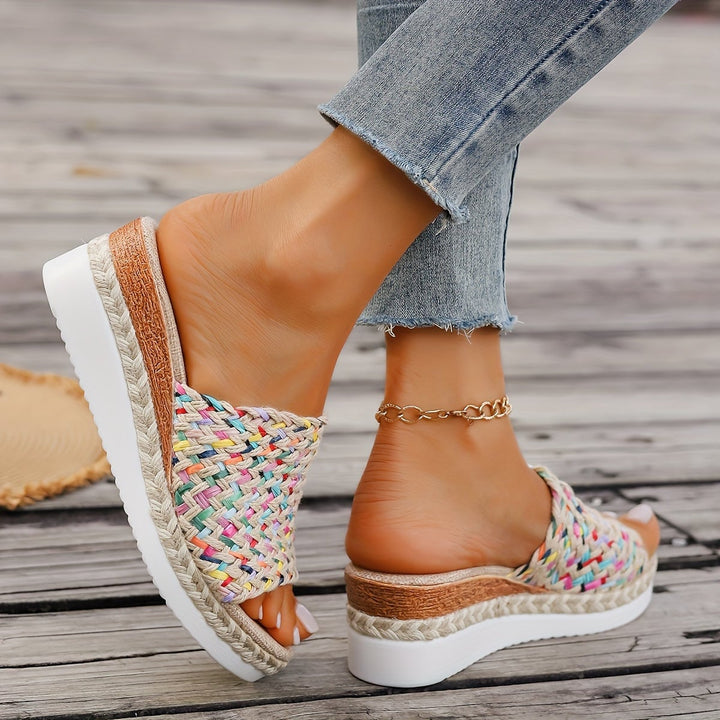 Pair of Celeste woven wedge sandals in beige arranged flat lay on a neutral surface