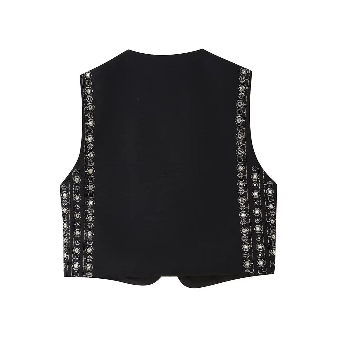 Close-up of intricate sequin embroidery detailing on black boho vest