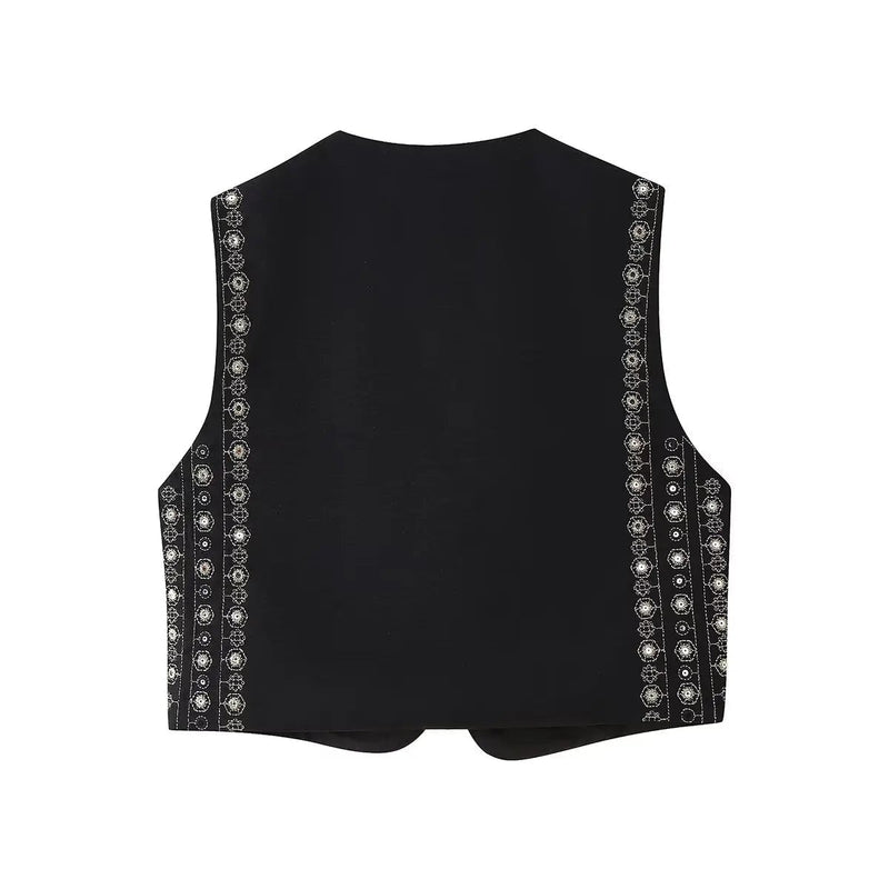 Close-up of intricate sequin embroidery detailing on black boho vest