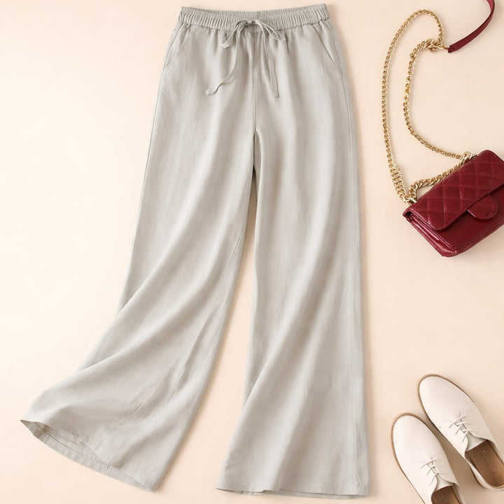 Model wearing relaxed drawstring pants in brown, paired with a simple top