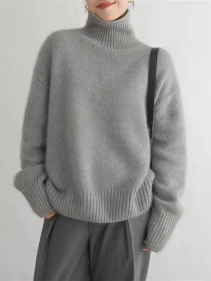 Detail shot of the ribbed high collar and soft knit fabric of the Chloe sweater
