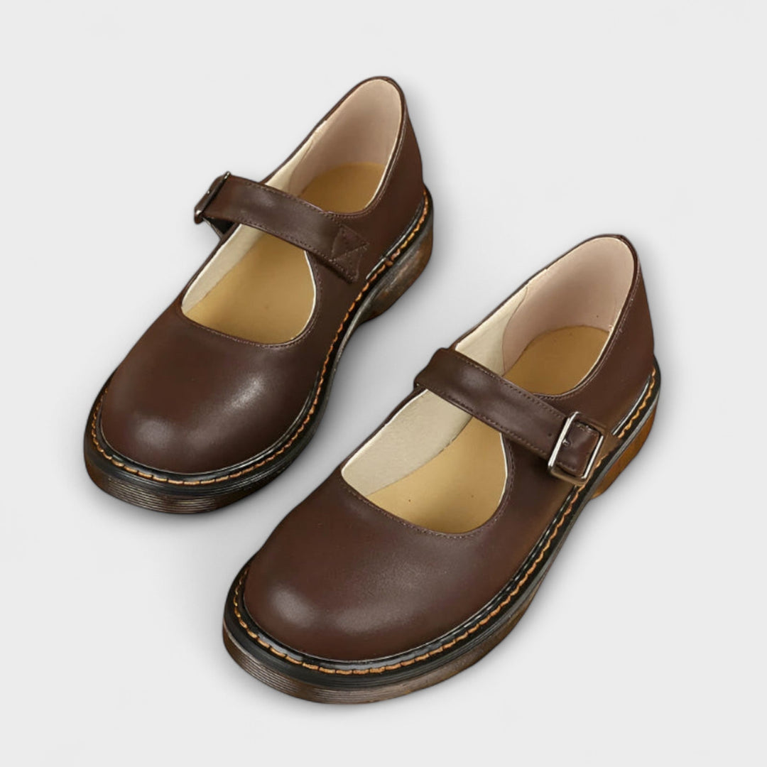 Women's brown Mary Jane flat with copper buckle strap and rounded toe, side view