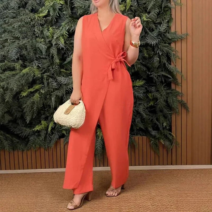 Woman wearing an orange sleeveless wrap V-neck wide-leg jumpsuit with a self-tie waist belt, front view