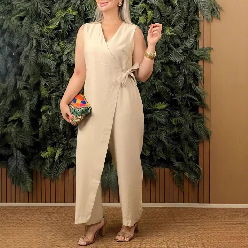 Close-up of the wrap V-neckline and self-tie belt detail on an orange wide-leg jumpsuit