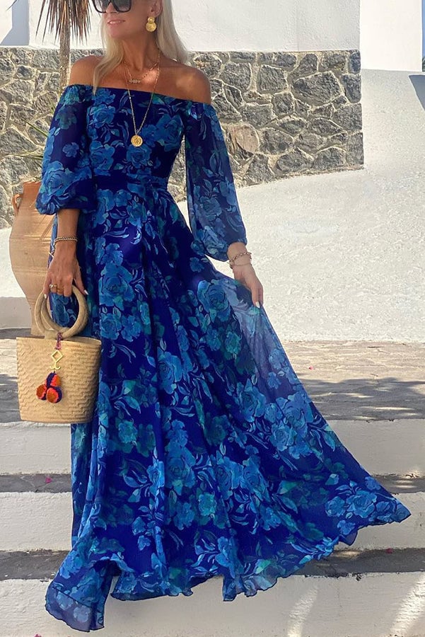Woman wearing a blue floral off-shoulder maxi dress with a flowing silhouette, styled for a summer occasion