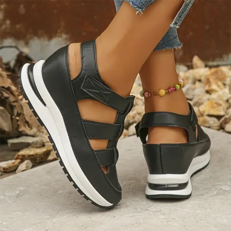 Side profile of Diane sneakers in black showing cushioned insole and adjustable strap detail