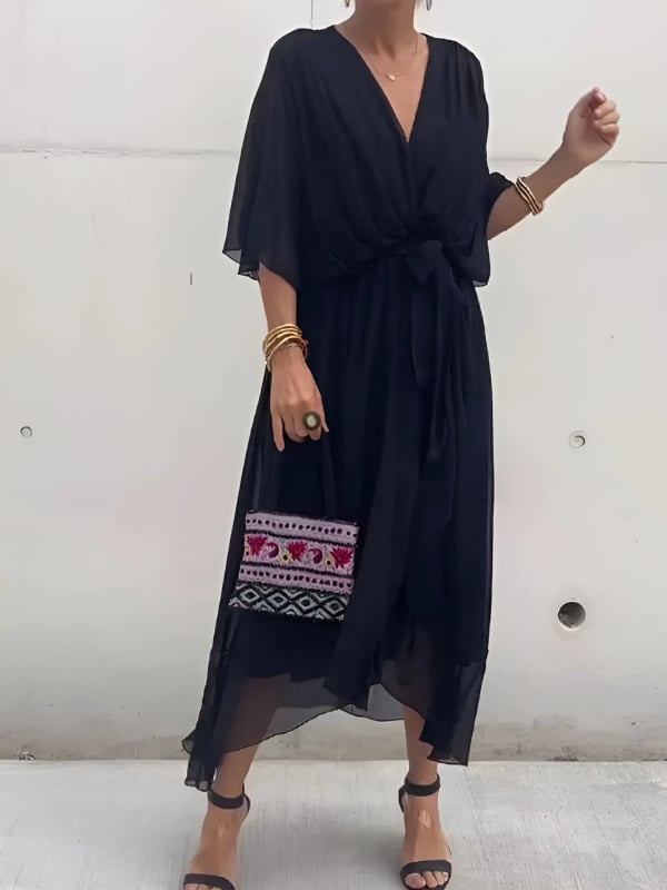 Woman wearing the Eden wrap midi dress in black with a flowing draped silhouette and waist-defining tie
