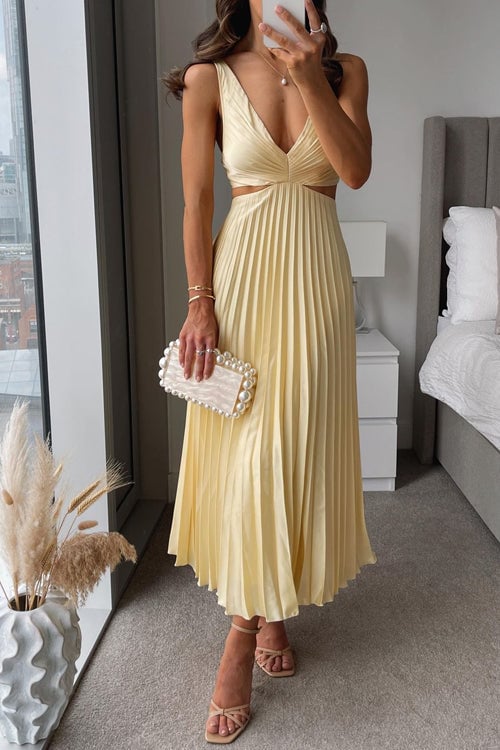 Woman wearing a yellow V-neck maxi dress with a flowing silhouette, styled for a wedding guest occasion