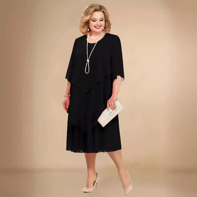 Model wearing the Ellen elegant chiffon dress in black, showing flowing layers and knee-length silhouette