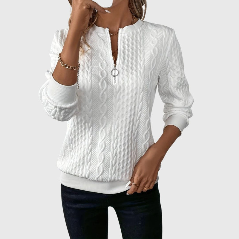 Woman wearing the Emily elegant sweater in a soft, flattering silhouette against a neutral background