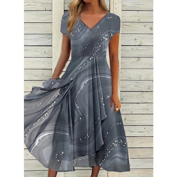 Close-up of the chic patchwork detail and V-neckline on a flowing midi dress in blue