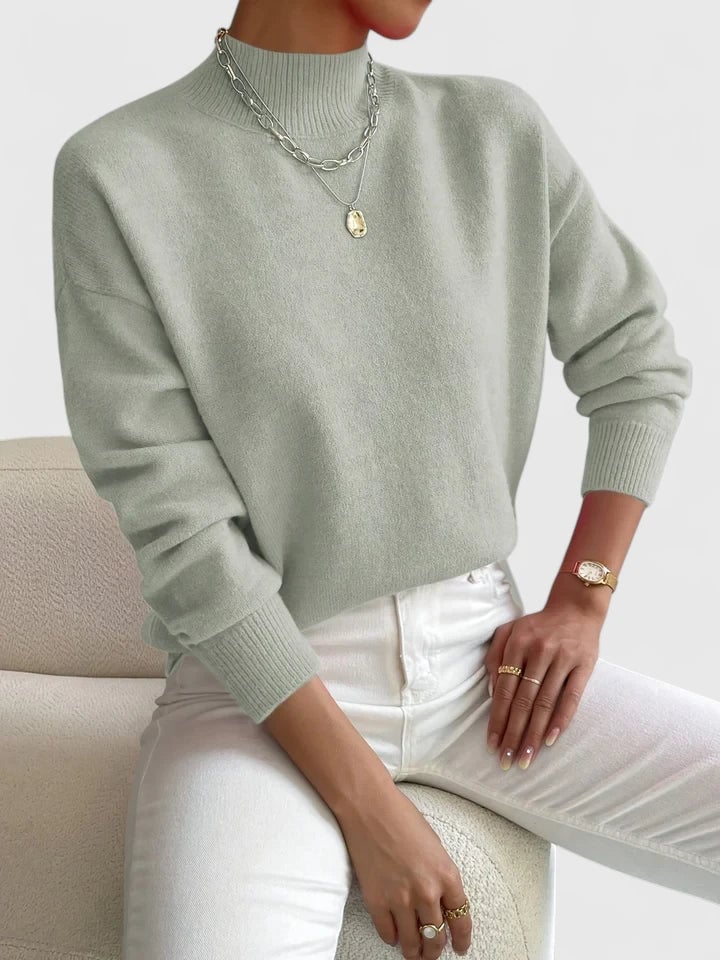 Full-length shot of a woman in the Evelyn turtleneck sweater in white on a clean background
