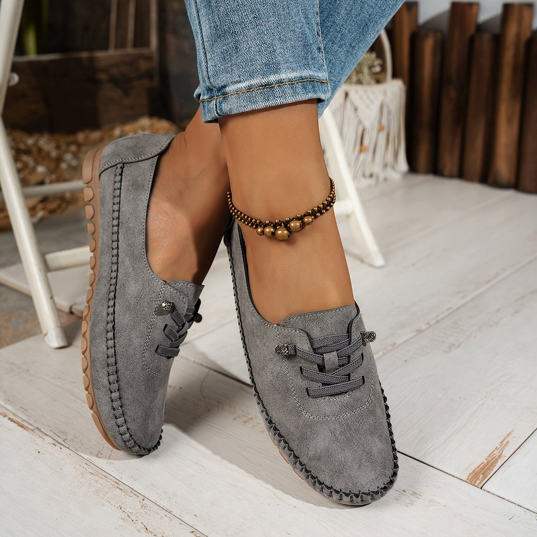 Close-up of Evelyne loafer lace-up detail in gray