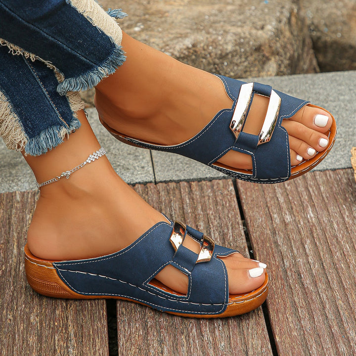 Side view of Everly buckle sandals in navy blue showing cushioned footbed detail