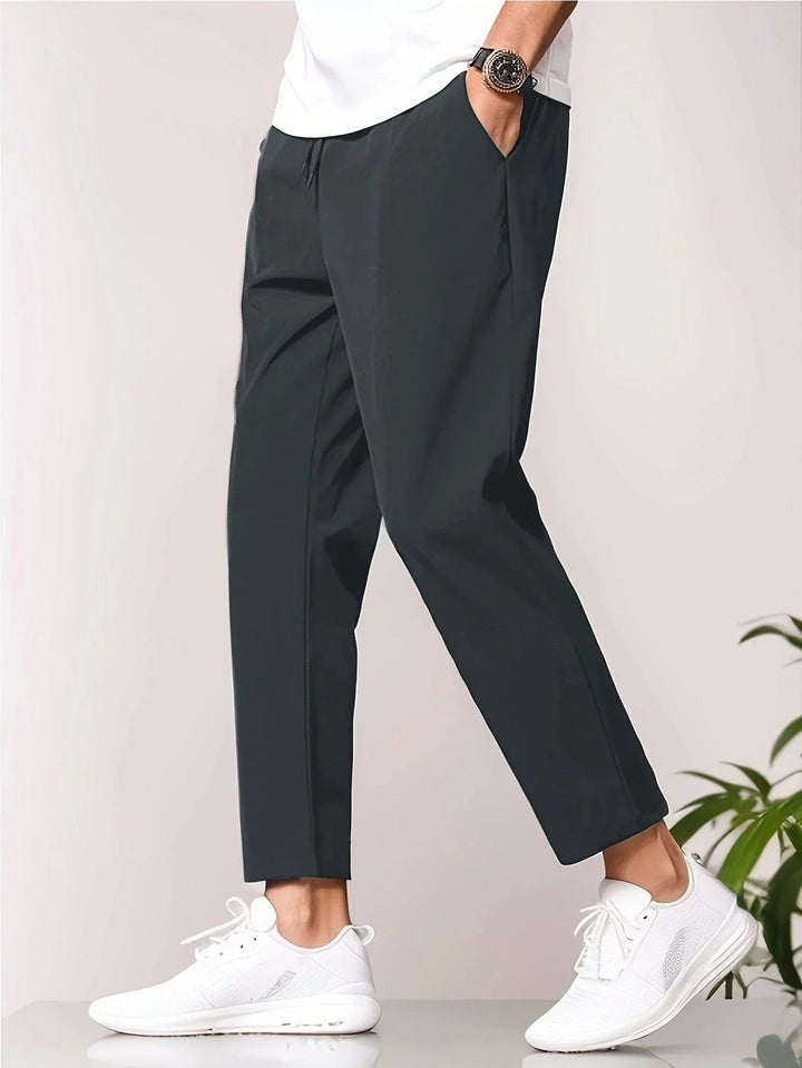 Model wearing lightweight grey relaxed-fit casual pants with a simple white tee, front view