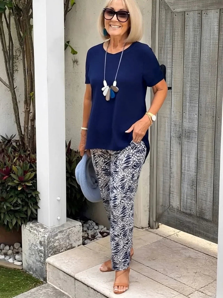Woman wearing the BobaFashion Coastal Set in navy blue, featuring a relaxed blouse and matching wide-leg pants, standing in a bright outdoor setting