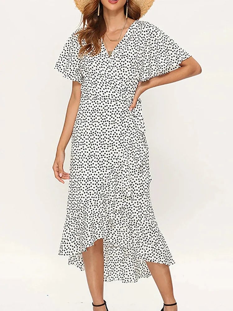 Front view of a floral maxi dress in white with delicate ruffle detailing and an elegant side slit