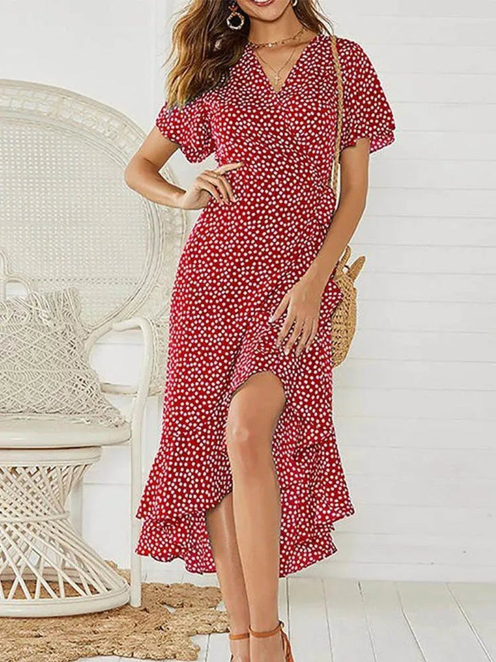 Full-length view of a black floral maxi dress with V-neckline, modeled against a bright background