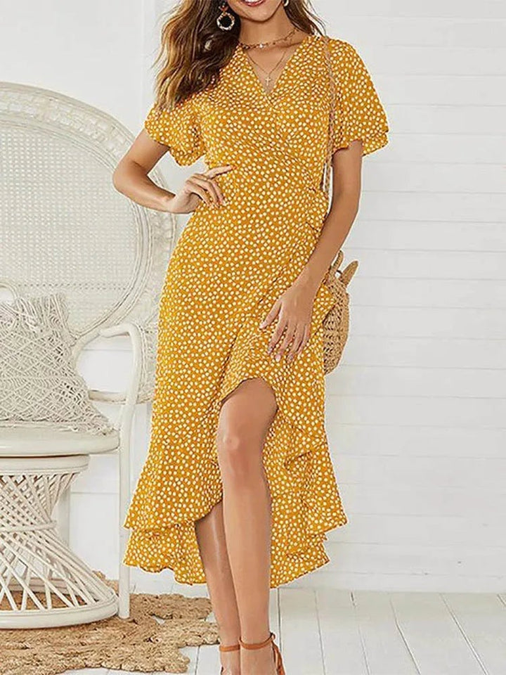 Woman in a white floral maxi dress accessorized with sandals for a beach-ready summer look