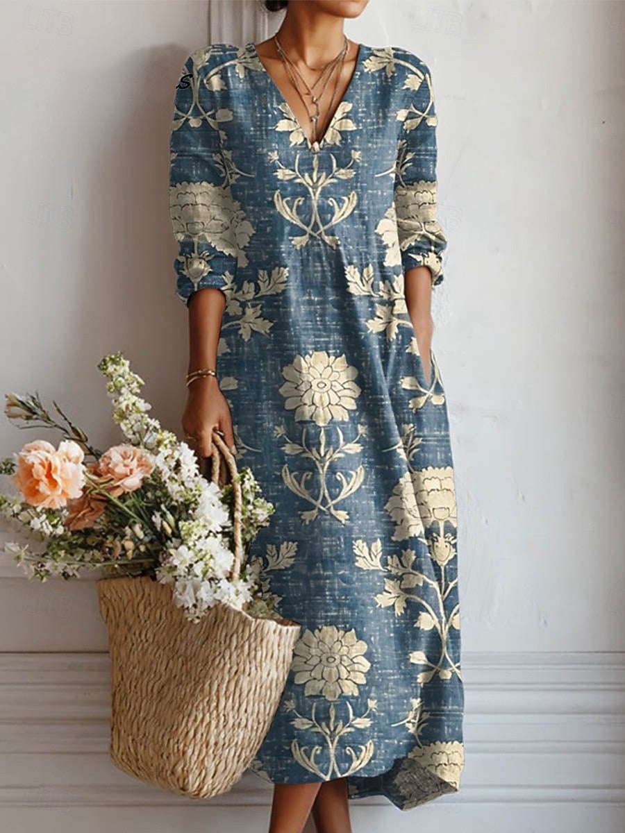 Woman wearing the Juniper blue and cream floral v-neck long sleeve midi dress with a relaxed, vintage-inspired silhouette