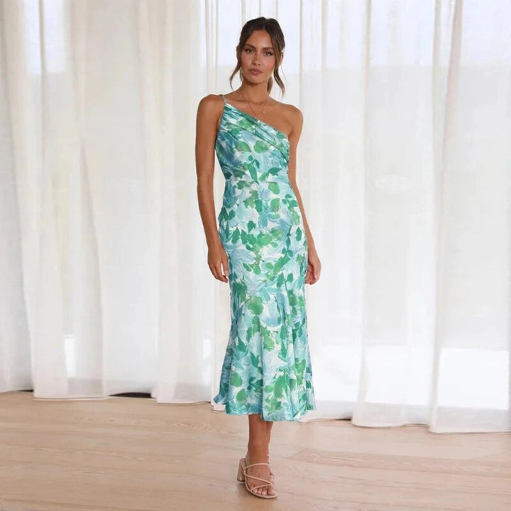 Lifestyle shot of a woman in a floral one-shoulder maxi dress paired with strappy sandals