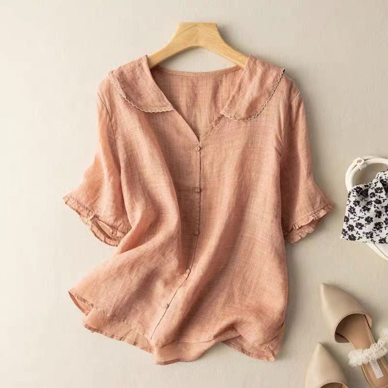 Close-up of the delicate scalloped collar and button detail on a vintage-inspired women's blouse