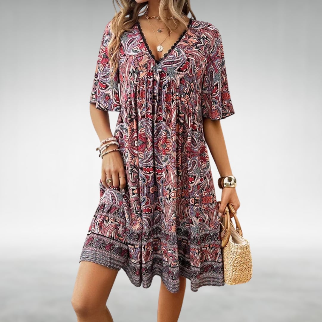 Model styling the Laurel paisley boho mini dress in yellow with sandals for a vacation look