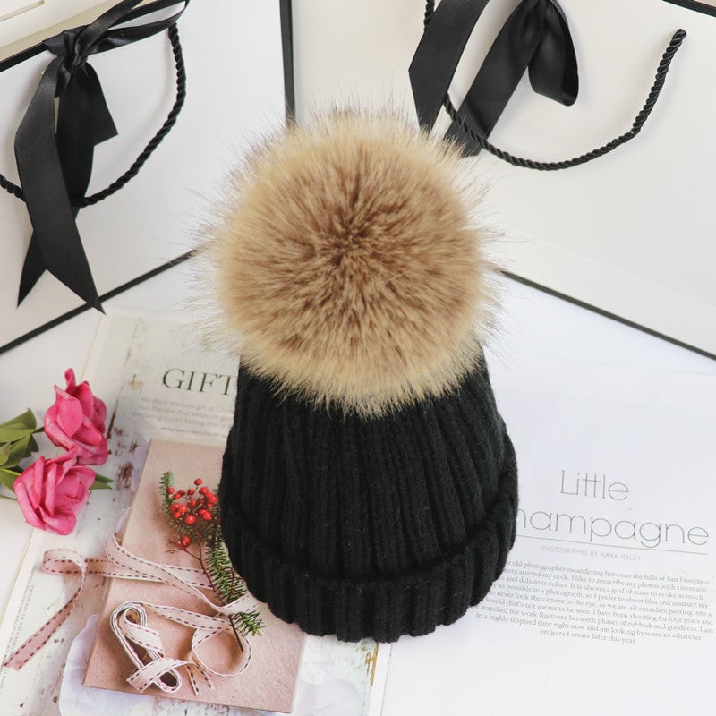 Woman tucking hair under the Lorette knit beanie in rose red