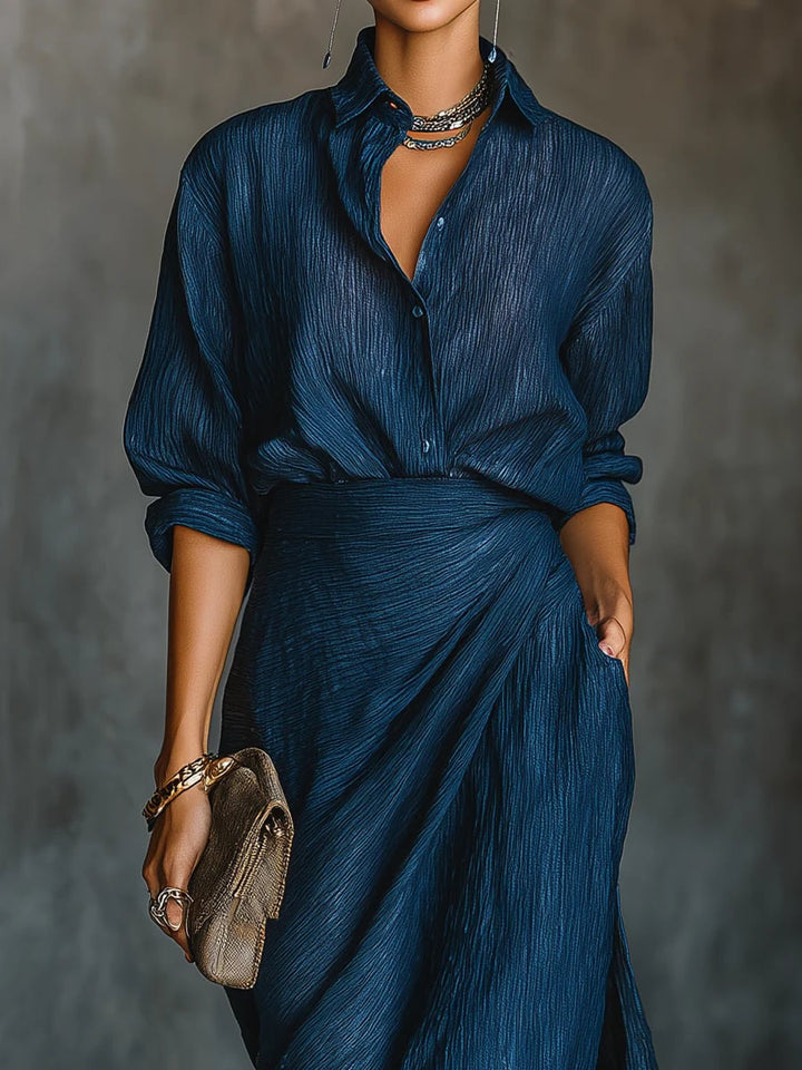 Close-up detail of the dark blue long skirt and matching shirt set showing flowing silhouette