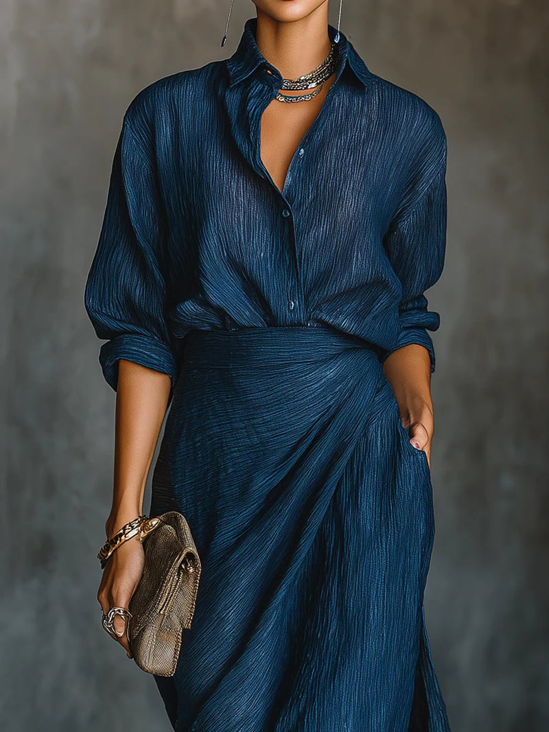 Close-up detail of the dark blue long skirt and matching shirt set showing flowing silhouette