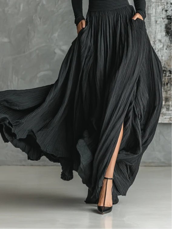Close-up detail of the black pleated skirt fabric and turtleneck neckline styling
